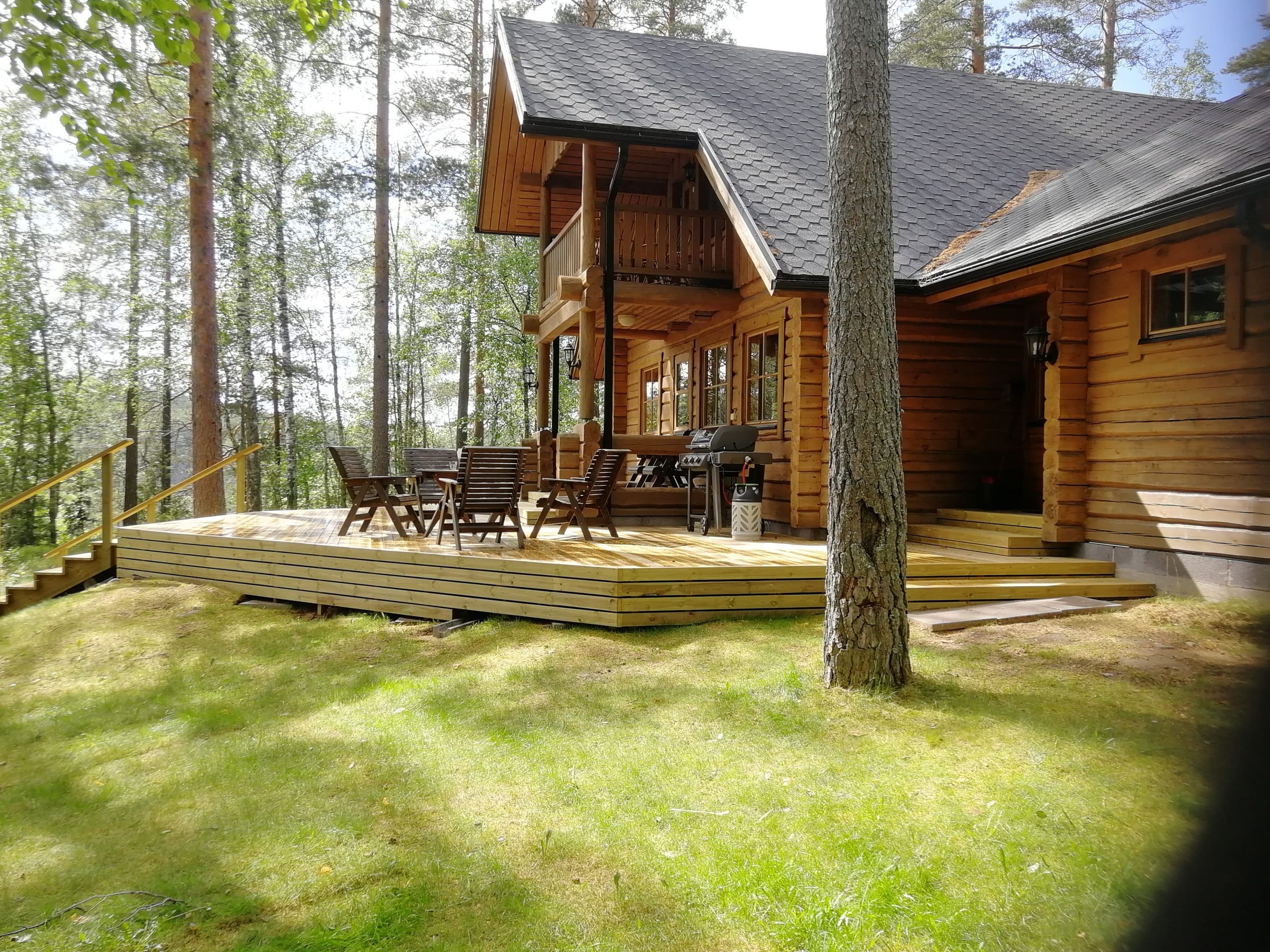 Ulkokuva kauniista hirsimokista jonka edustalla iso terassi